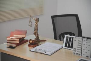 A desk with a statue of a judge and books photo