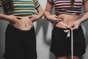 Two women standing next to each other with measuring tape photo