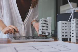 A woman is working on a model of a building photo