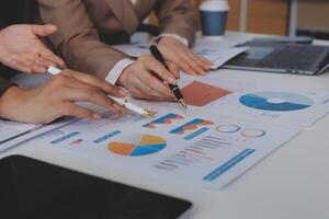 Business people working on a project with graphs and papers photo