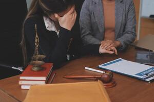 Two women in business attire sitting at a desk with a gavel photo