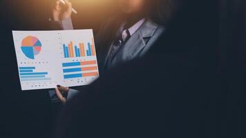 A woman in a business suit holding a piece of paper with graphs on it photo