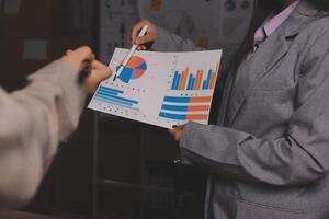 A business person is holding a piece of paper with graphs on it photo
