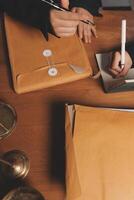 A person in a suit is writing on a piece of paper photo
