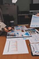 A person is looking at a table with papers and graphs photo
