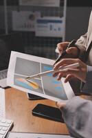 Business people working on a document with graphs and charts photo
