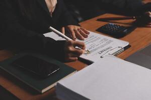 A person is writing on a piece of paper while sitting at a desk photo