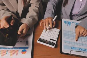 Two business people are working on a calculator and papers photo