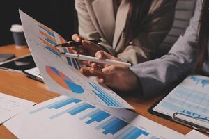Two business people are looking at graphs on papers photo