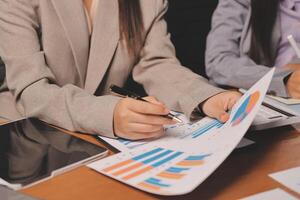 Business people working on papers with pen and pen photo