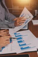 Business people working on graphs and papers photo