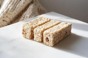 This image showcases three nutritious snack bars arranged neatly on a white marble table. Ideal for healthy eating and fitness lifestyles. photo