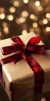 Elegant gold gift box with a red ribbon, perfect for holiday celebrations and special occasions, set against a festive bokeh background. photo
