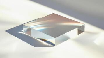 A square piece of glass is sitting on a white surface. The glass is reflecting the light from the sun photo