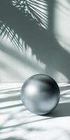 Metallic Sphere Surrounded by Soft Shadows and Natural Patterns photo