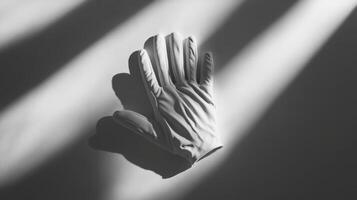 A white glove is laying on a table. The glove is not on a person's hand photo