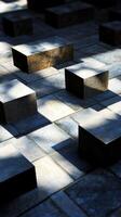 An artistic view of stone blocks arranged in an urban setting, showcasing the interplay of shadows and light. The geometric shapes create a minimalist and modern aesthetic. photo