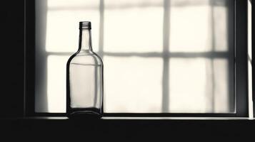 A bottle of alcohol is sitting on a window sill. The bottle is empty. The window is open photo