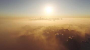A stunning aerial view capturing the golden sunrise illuminating a city skyline shrouded in soft morning fog. The tranquil scene evokes a sense of calm and serenity. photo