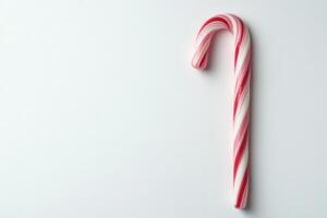 Red and white candy cane is shown on a white background. The candy cane is the only object in the image photo