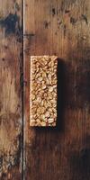 A nutritious oat bar sits atop a rustic wooden table, showcasing its crunchy texture and natural ingredients. Perfect for healthy snacking or breakfast on the go. photo