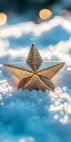A glittering golden star ornament sits on fresh snow, surrounded by a dreamy bokeh of warm lights. photo