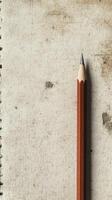 A pencil is on a white surface. The pencil is sharpened. The pencil is on a piece of paper photo