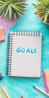 A colorful workspace featuring a notebook with Goals photo