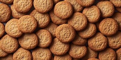 A close-up view of freshly baked cookies piled together, showcasing their golden color and inviting texture, perfect for dessert or a sweet snack. photo