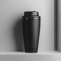Stylish black travel mug against a minimalist gray backdrop, ideal for eco-friendly and modern lifestyle themes. photo