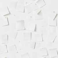 A collection of blank white sticky notes arranged on a wall, forming a minimalist and modern abstract background. photo