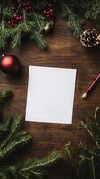 White card sits on a wooden table with a red ornament and a pencil. The card is empty photo