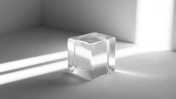 A single ice cube on a white surface, casting dramatic shadows in natural light, showcasing minimalist design. photo