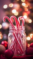 Jar of red and white candy cane candies sits on a table next to a Christmas tree photo