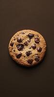 A close up of a chocolate chip cookie. The cookie is brown and has chocolate chips on it photo