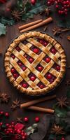 Pie with a lattice crust and berries on top. The pie is surrounded by cinnamon sticks and berries photo