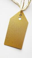 Close-up of a gold textured tag with twine string, perfect for retail, gift packaging, and branding design. photo
