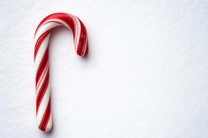 A classic red and white candy cane on a snowy white background, ideal for holiday and Christmas-themed designs and promotions. photo
