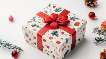 White box with a red bow on top of it. The box is decorated with Christmas trees and other festive decorations photo