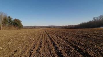 A field of dirt with a blue sky in the background. The sky is clear and the sun is shining brightly photo