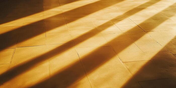 Sunlight creates dramatic shadows on a tiled floor, highlighting the warm tones and textures of the surface. photo