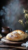 A loaf of bread with a sprinkle of sugar on top sits on a wooden cutting board photo