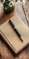 A sophisticated black fountain pen placed on a brown notebook, accompanied by a vase of daisies on a rustic wooden table. photo