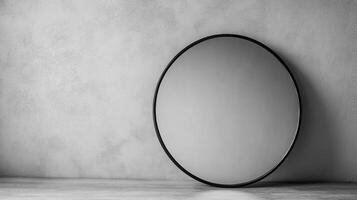 A sleek round mirror leaning against a textured gray wall, showcasing minimalist interior design and contemporary style. photo