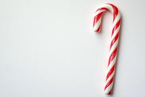 Red and white candy cane is on a white background. The candy cane is the main focus of the image photo