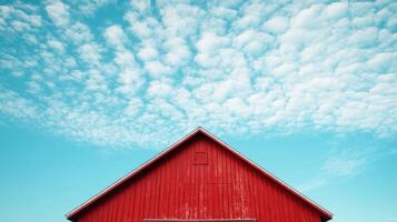 A red barn with a blue sky in the background. The barn is the main focus of the image, and the blue sky in the background creates a sense of calm and serenity photo