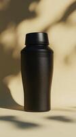 Stylish black insulated water bottle with a minimalist design, casting soft shadows on a neutral background. photo
