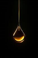A single golden oil drop suspended against a dark background, showcasing elegance and simplicity in a minimalist style. photo