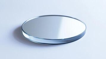 A clear glass object with a mirror on it. The glass is round and has a reflective surface photo
