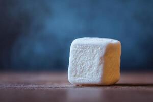 Close-Up View of a Single Sugar Cube on Wooden Table with Background photo